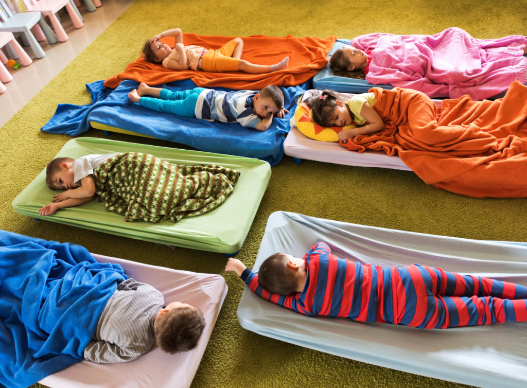 Baby sleeping calmly in a nursery cot — routine development showing baby ready for nursery and daily nursery transitions